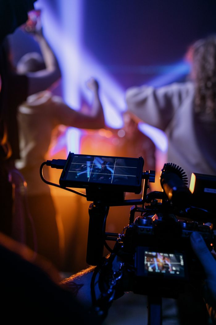 The Art of Drawing Readers In: Your attractive post title goes here Dynamic scene showing concert filming with professional equipment and vibrant lights.
